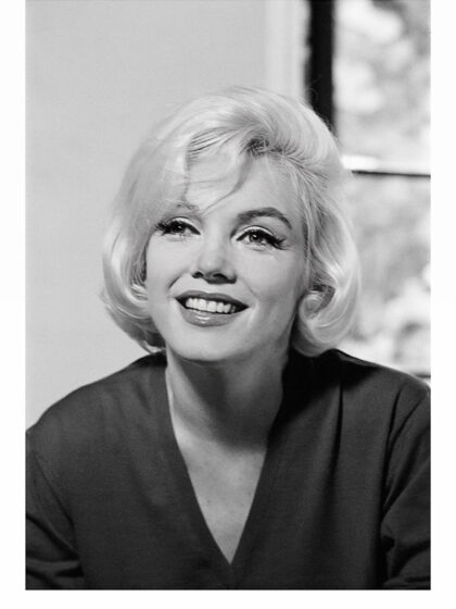 Schwarz-Weiß-Nahporträt der lächelnden Marilyn Monroe mit leicht nach oben gerichtetem Blick