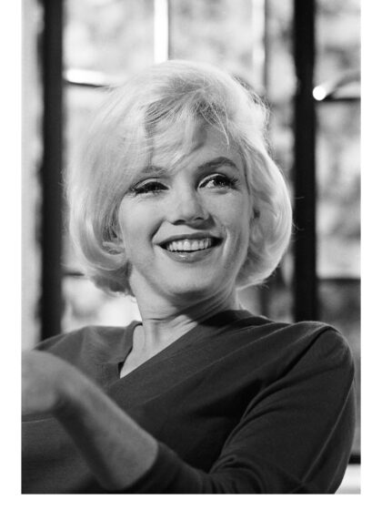 Schwarz-Weiß-Porträt der lachenden Marilyn Monroe mit leicht nach oben gerichtetem Blick
