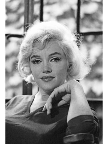 Großformatiges Schwarz-Weiß-Porträt von Marilyn Monroe mit direktem Blick und locker angehobener Hand