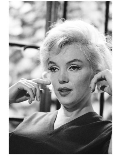 Schwarz-Weiß-Porträt von Marilyn Monroe mit beiden Händen auf Höhe ihres Gesichts