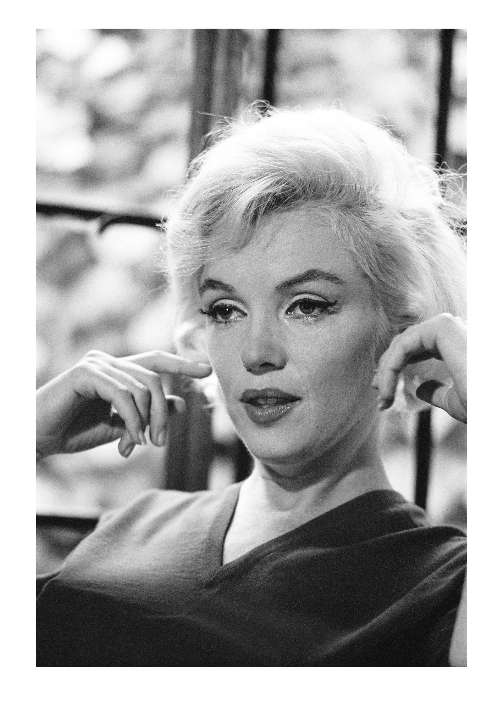 Schwarz-Weiß-Porträt von Marilyn Monroe mit beiden Händen auf Höhe ihres Gesichts